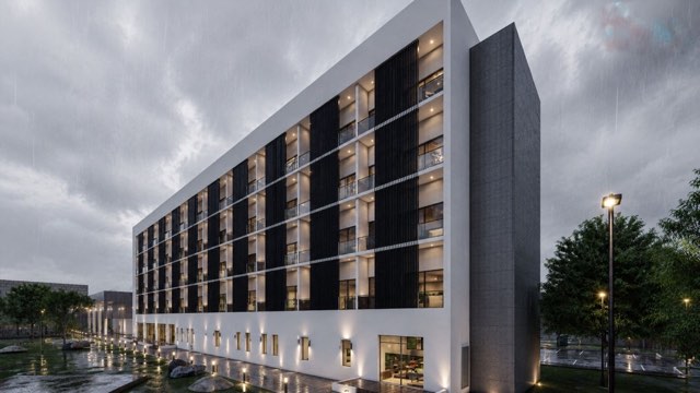 Multihub residential wing facade in the rain at dusk